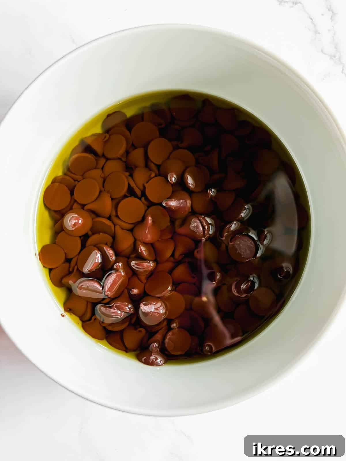 Liquid Gold Brownies 4 Semi-sweet chocolate chips melting in olive oil in a microwave-safe bowl.