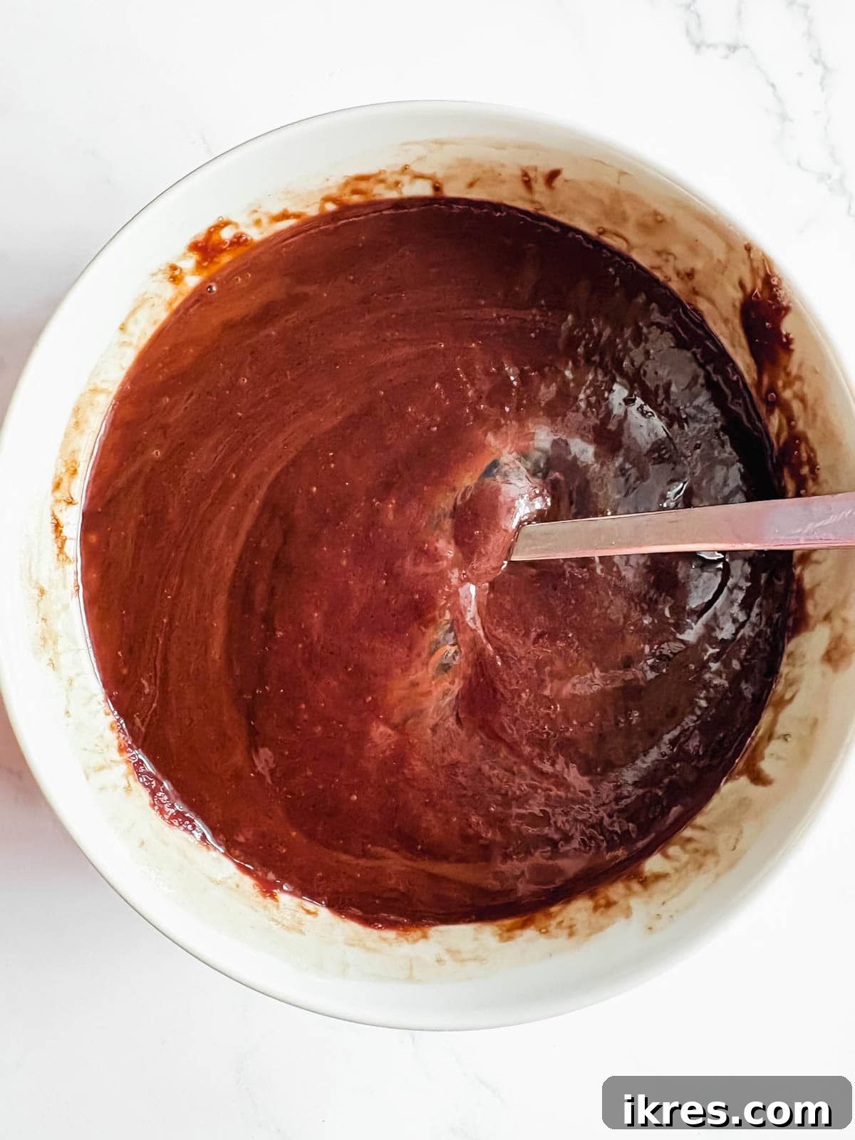 Liquid Gold Brownies 6 Three eggs being whisked into the chocolate mixture one by one.