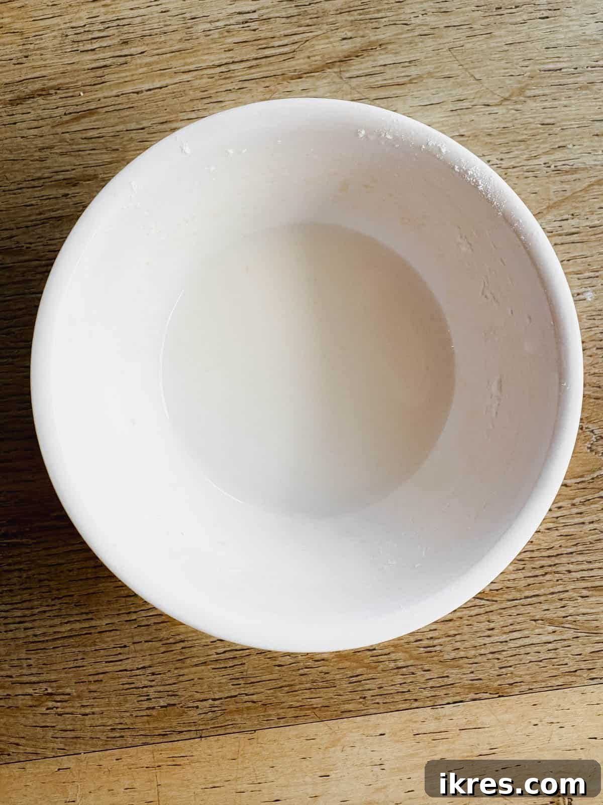 A small bowl showing white tapioca flour mixed into a clear liquid (water), forming a slurry.