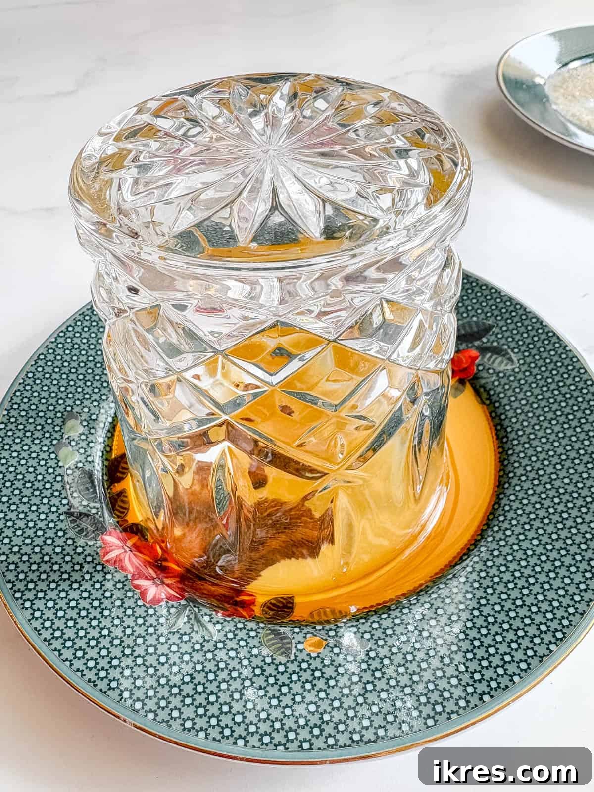 Glass rim being dipped in maple syrup on a small plate.