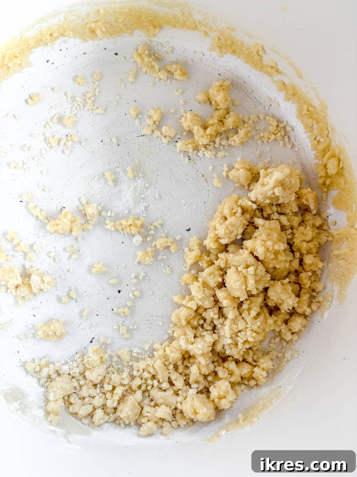 Flour being stirred into melted butter in a saucepan to create a roux.