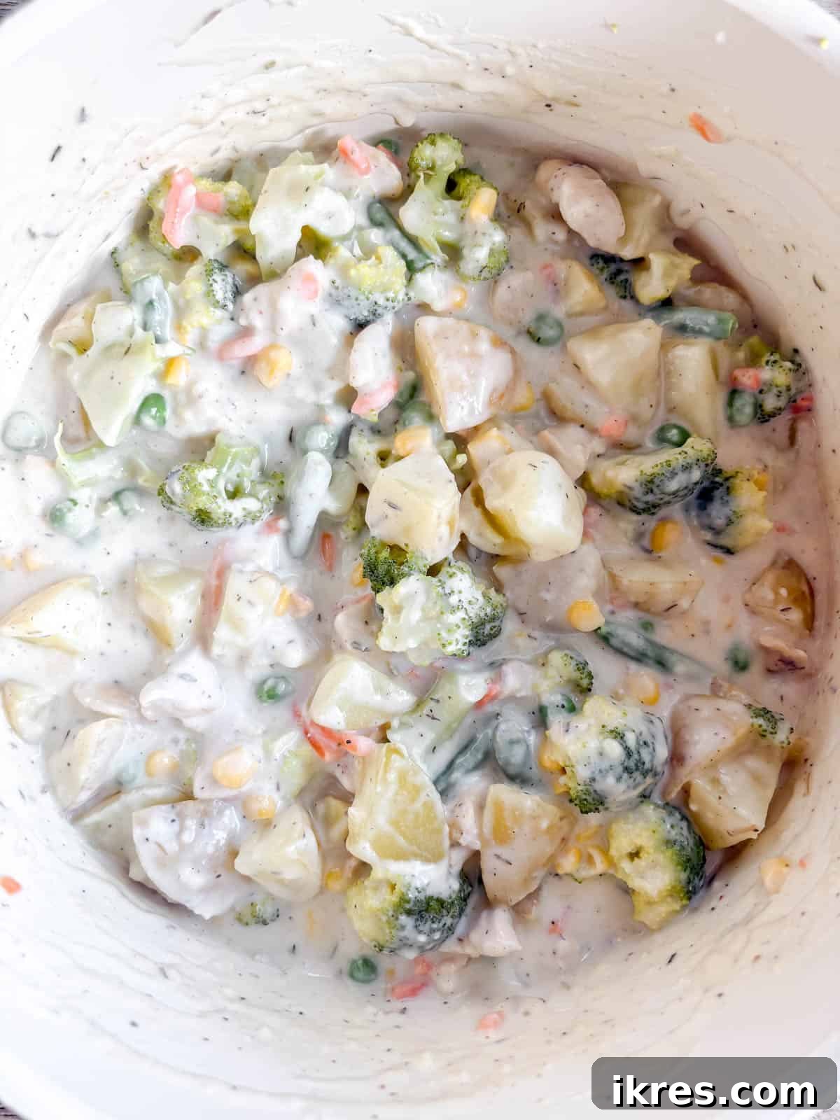 Cooked chicken, boiled potatoes and broccoli, and frozen mixed vegetables mixed into the creamy sauce.