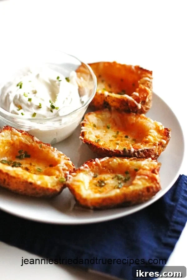 Ultimate Crispy Cheesy Bacon Potato Skins 2 Four golden-brown, crispy potato skins, generously loaded with melted cheese and fresh chives, presented beautifully on a clean white plate, ready to be enjoyed.