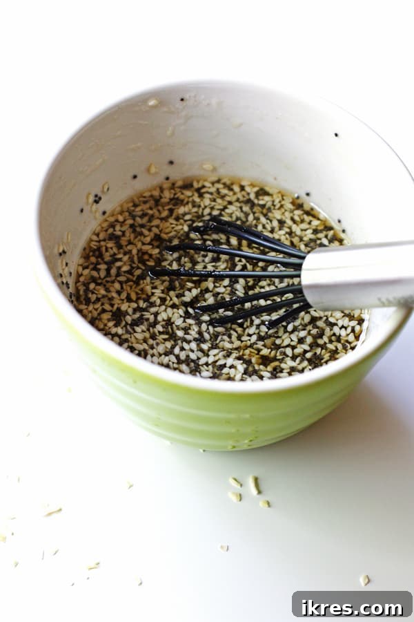 Close-up shot of homemade poppyseed salad dressing ingredients being whisked together in a bowl, creating a smooth and aromatic mixture.