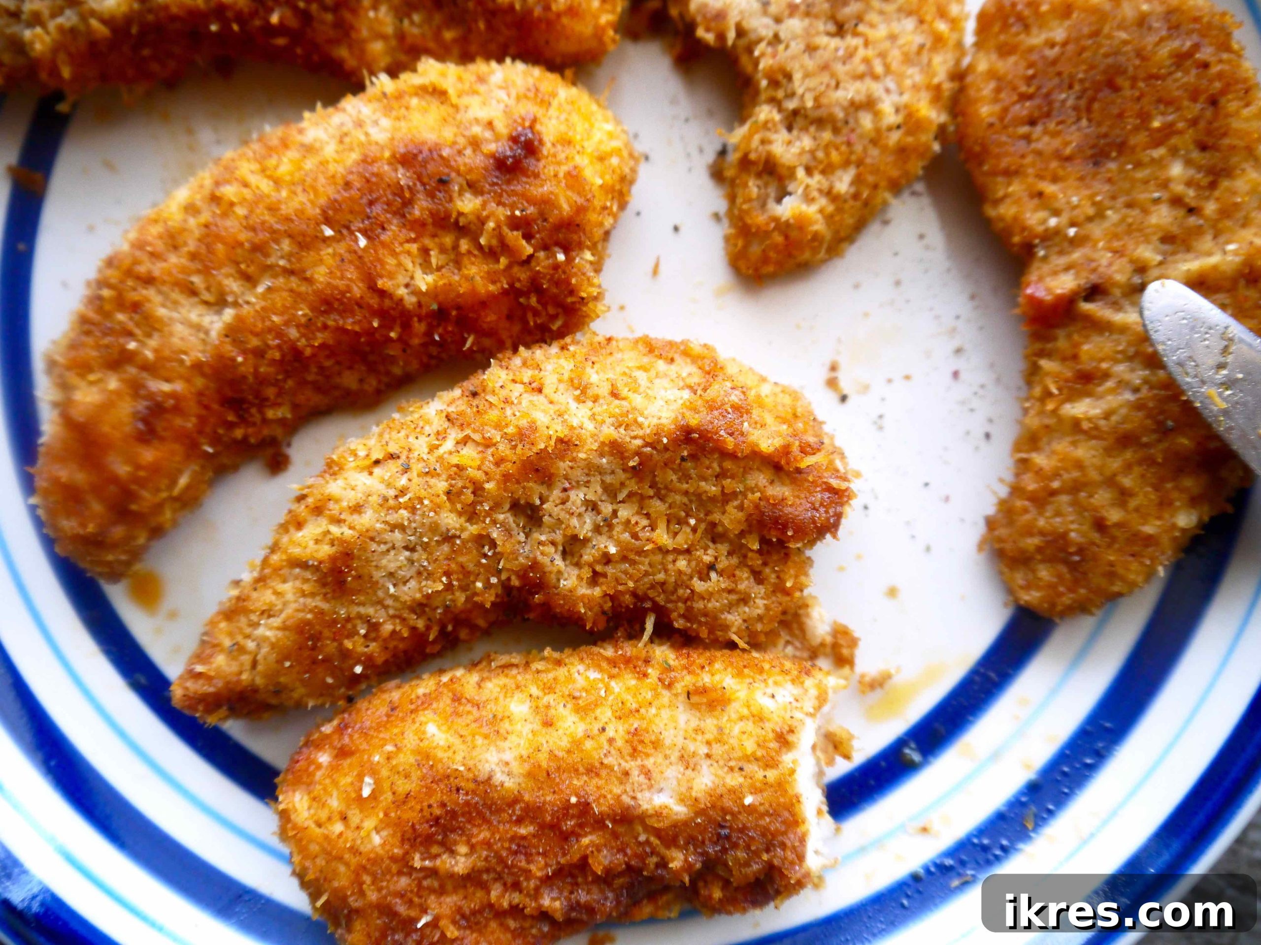 Freshly baked almond flour chicken tenders, golden and crispy, arranged on a serving plate.