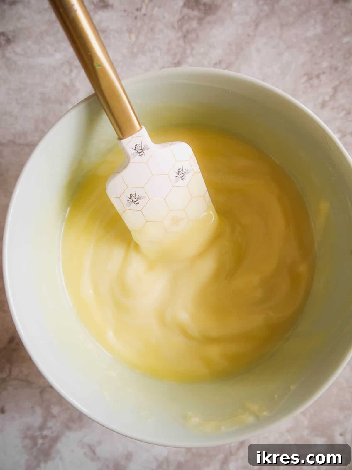Melted white chocolate and butter mixture in a heatproof bowl.
