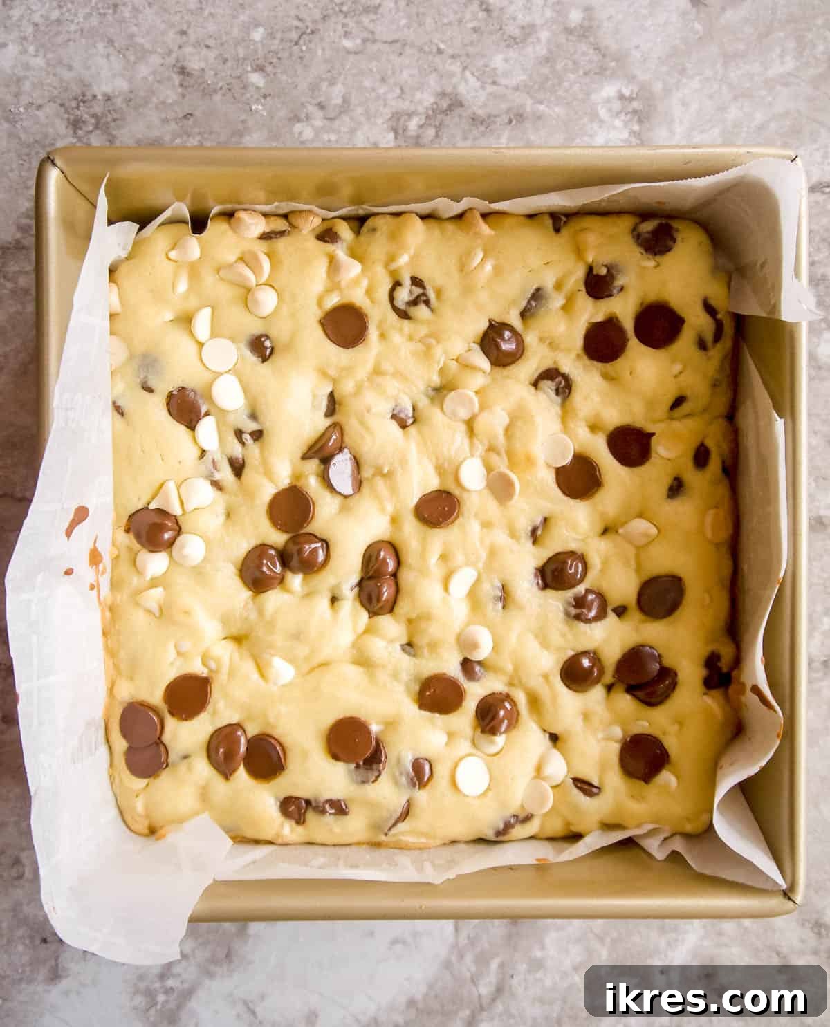 Golden-edged white chocolate brownies freshly baked in a pan.