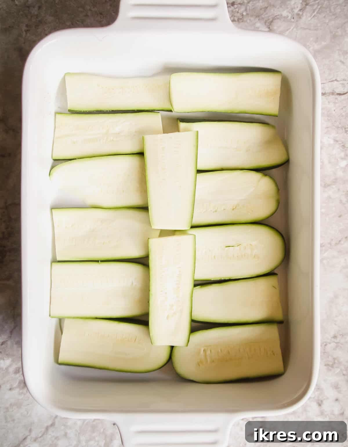 Zucchini Lasagna Reimagined: Gluten-Free, Meaty, and Mushroom Packed 5 Thinly sliced zucchini arranged neatly in a baking pan, ready for the next layer of the lasagna.