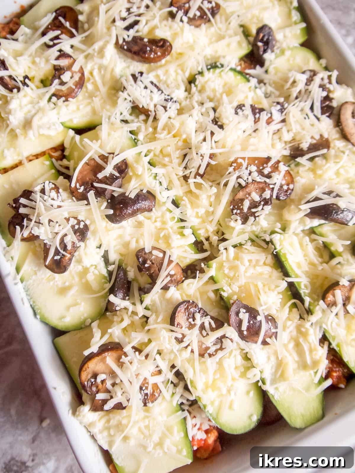 Zucchini Lasagna Reimagined: Gluten-Free, Meaty, and Mushroom Packed 9 A generous sprinkling of shredded cheese coats the top of the uncooked zucchini lasagna, promising a golden crust.