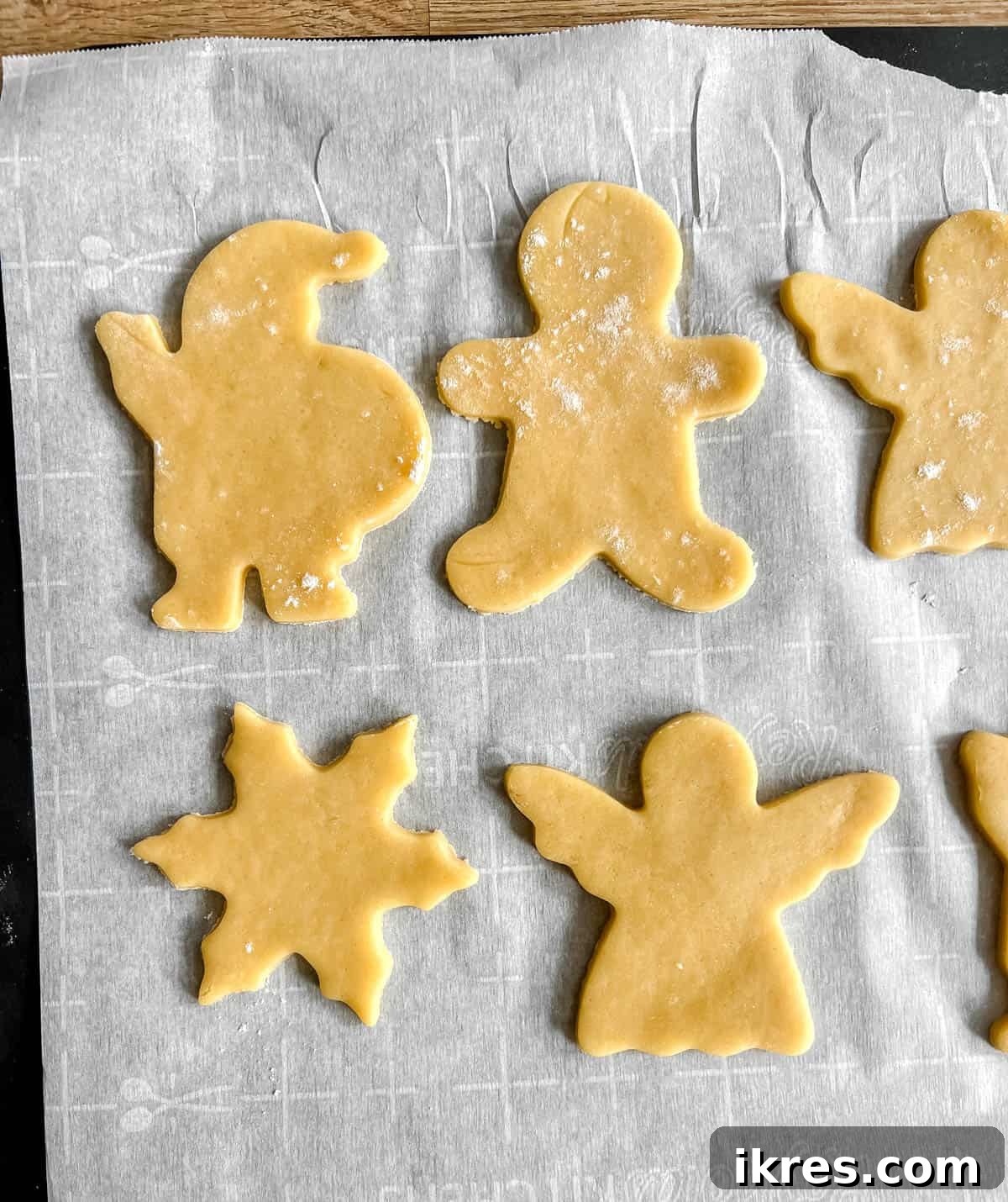 Unbaked sable cut out sugar cookies neatly arranged on a baking sheet, ready for the oven.