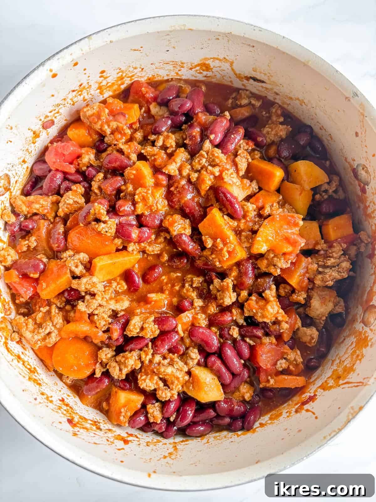 Kidney beans being added to the simmering turkey apple chili.