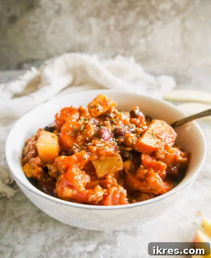 A side angle view of a bowl of comforting turkey apple chili, ready to be enjoyed.