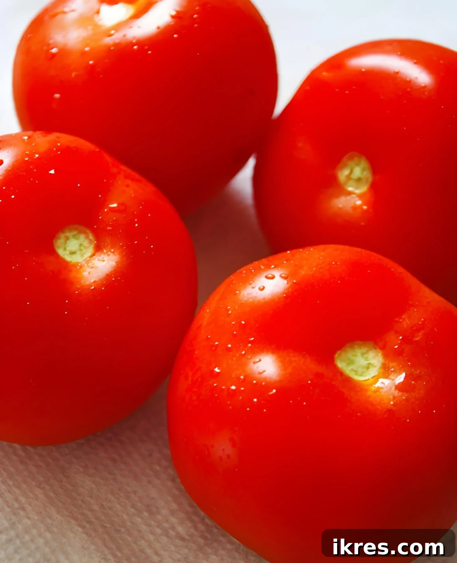 Close-up of ripe, red tomatoes on the vine, ready for slicing.