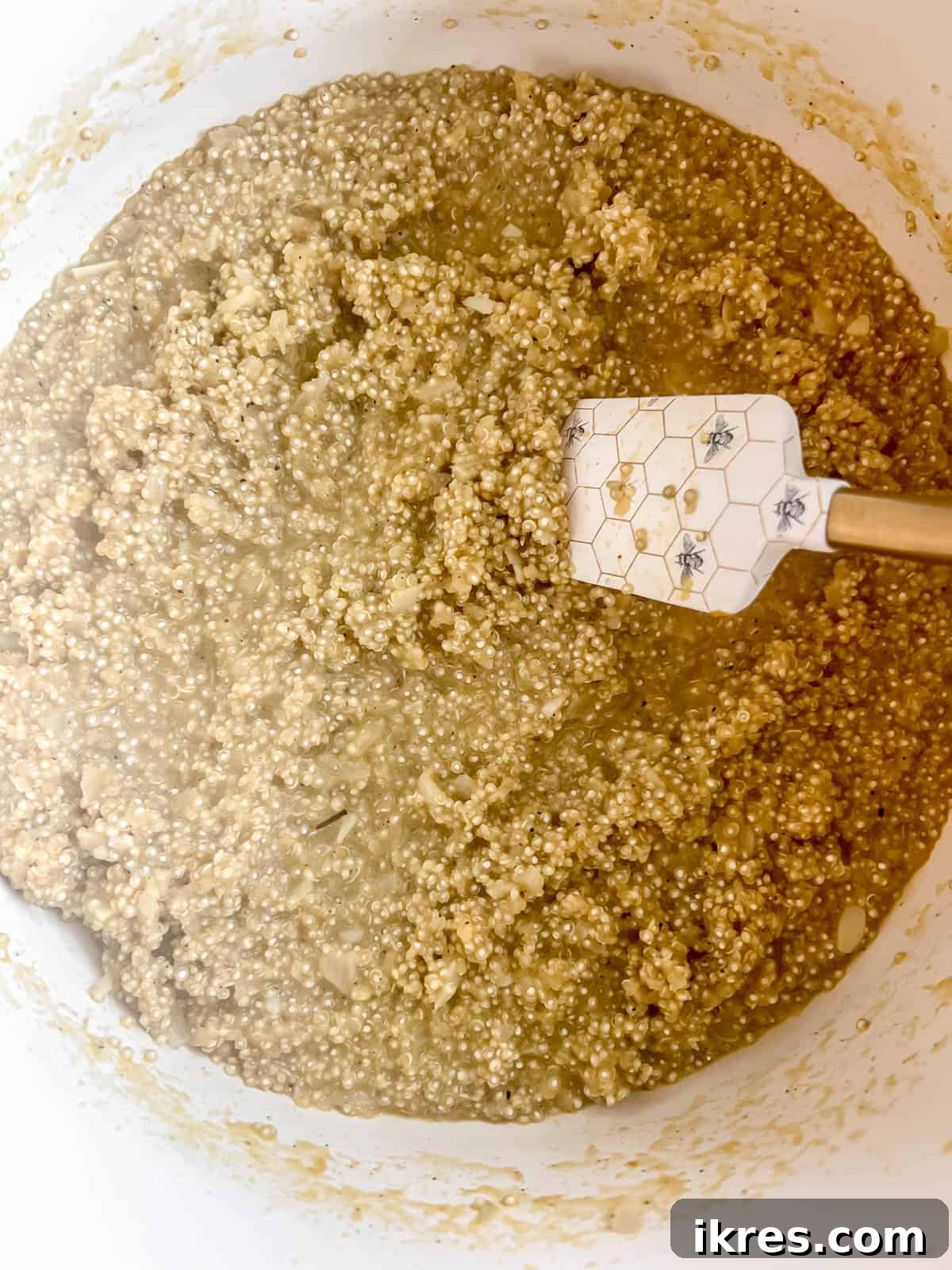 The quinoa risotto looking creamy and fully absorbed in a large pan, removed from heat.