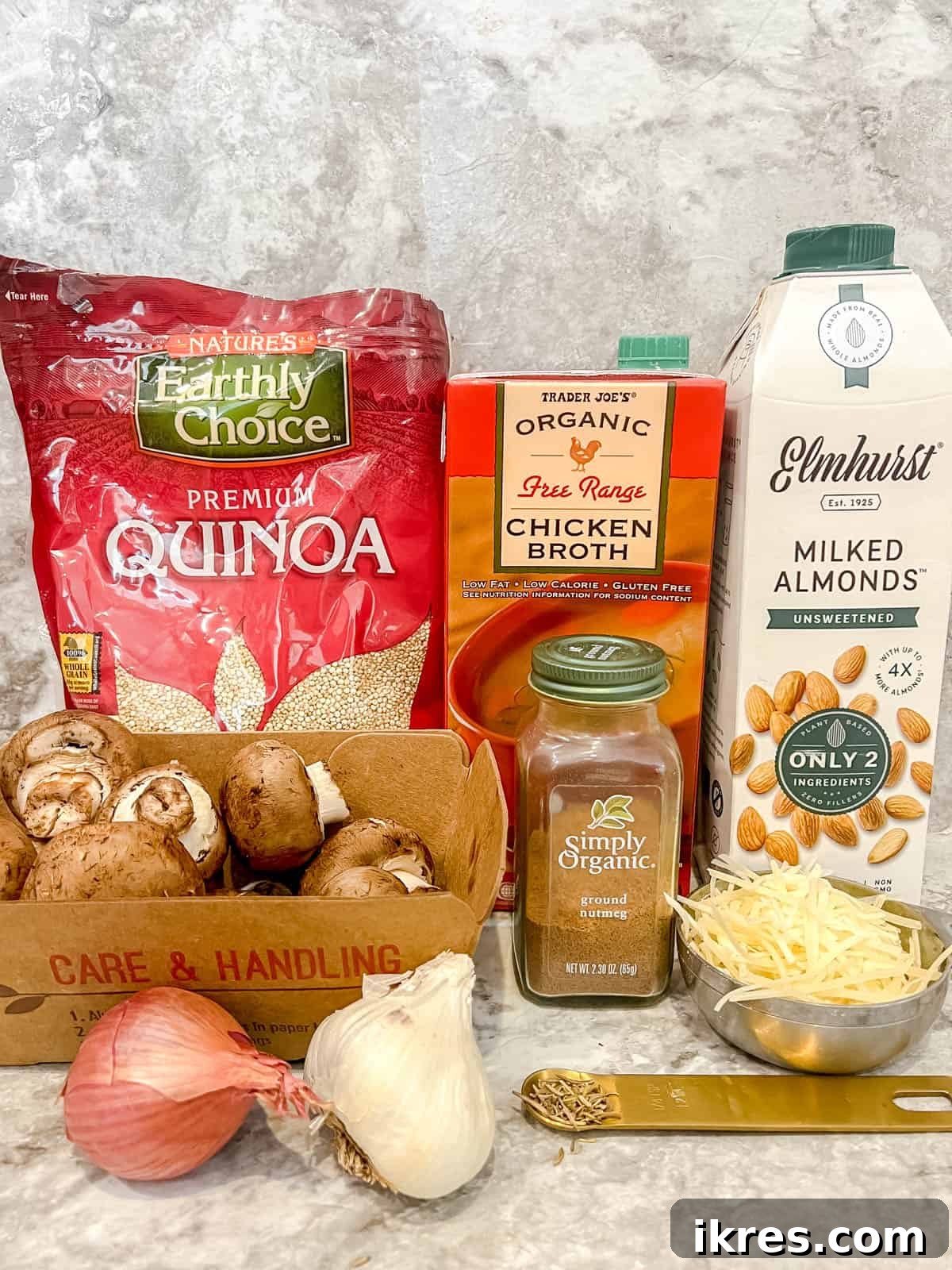 All the necessary ingredients laid out for preparing mushroom quinoa risotto, including fresh quinoa, shallots, garlic, mushrooms, and spices.