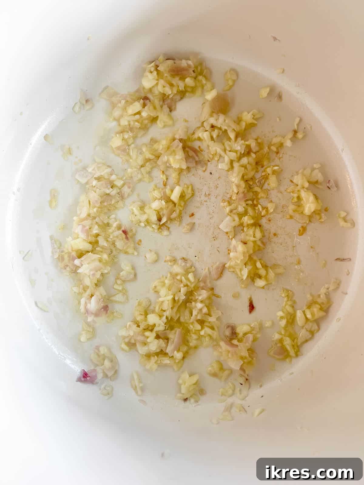 Finely minced shallots and garlic sautéing in olive oil in a large pan.