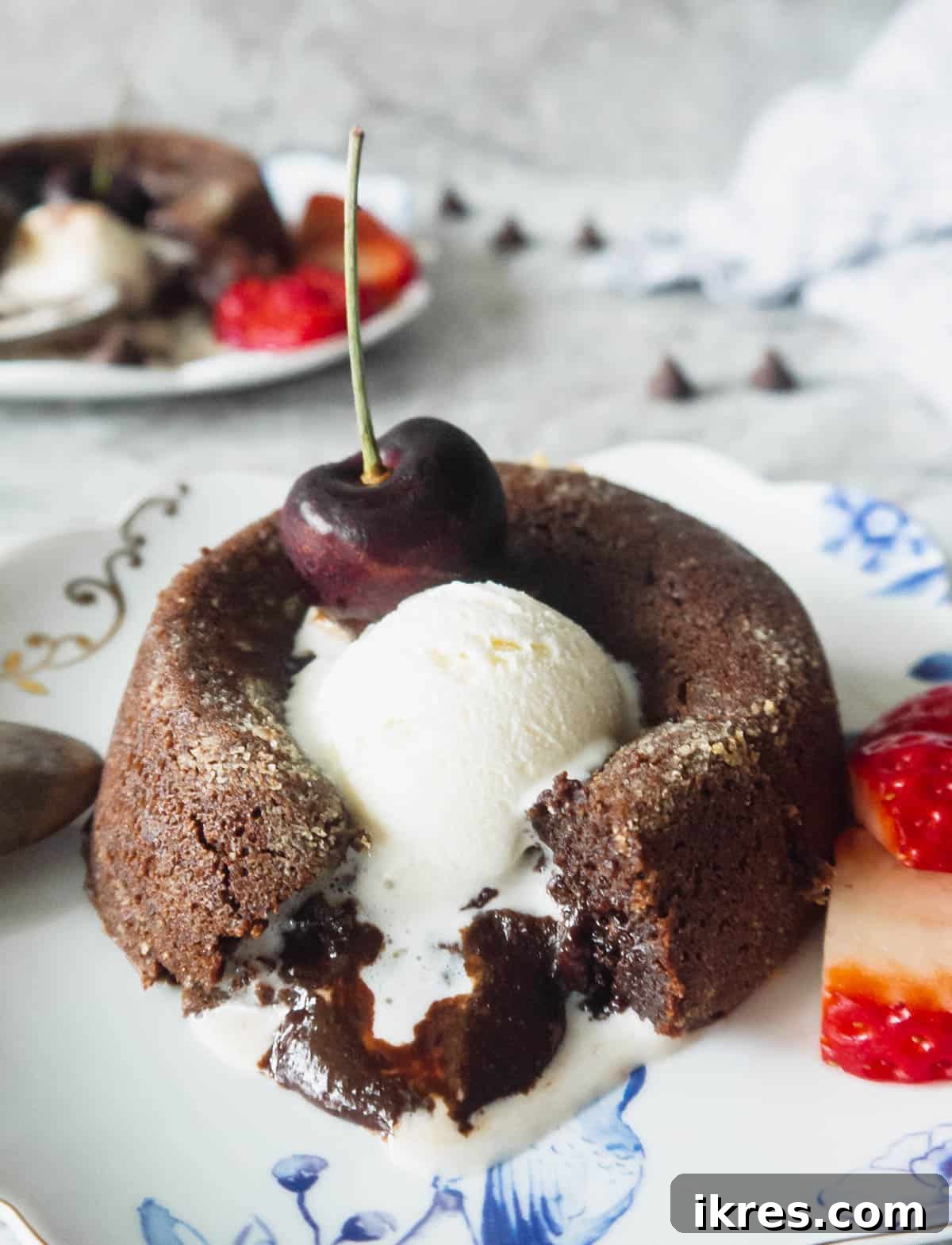 Decadent Gluten Dairy Free Molten Lava Cakes 13 A gluten-free chocolate molten lava cake, with a visible melted center, served with melting ice cream on top.