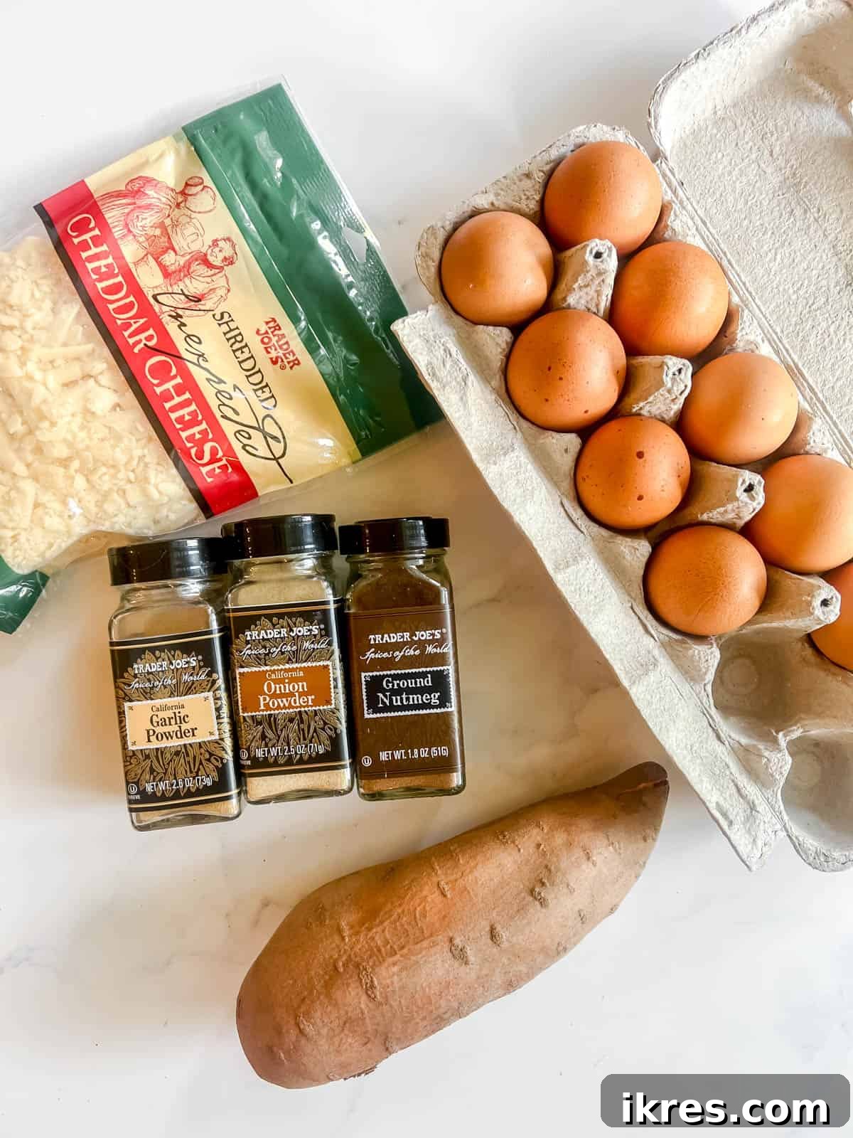 Fresh ingredients including large eggs, a sweet potato, and various spices laid out before preparation for egg cups.