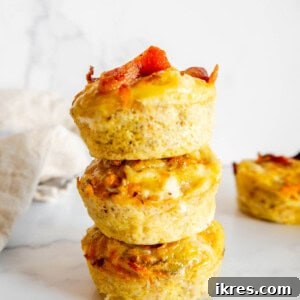 A vibrant image of golden-brown Sweet Potato Egg Cups with Bacon, stacked artfully on top of each other, ready to be enjoyed.