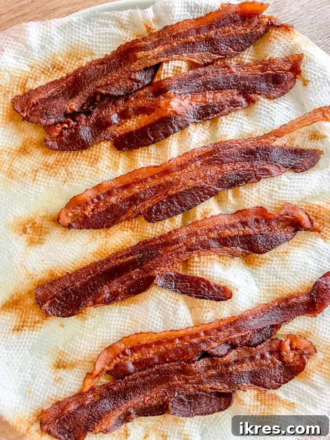 Four strips of crispy bacon, perfectly cooked and ready to be crumbled for inclusion in the egg cups.