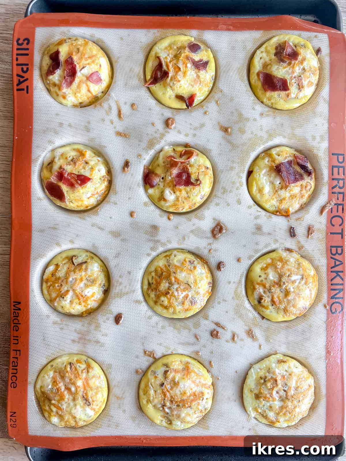 A batch of baked sweet potato egg bites, golden brown on top and perfectly risen, resting in a muffin tin after baking.