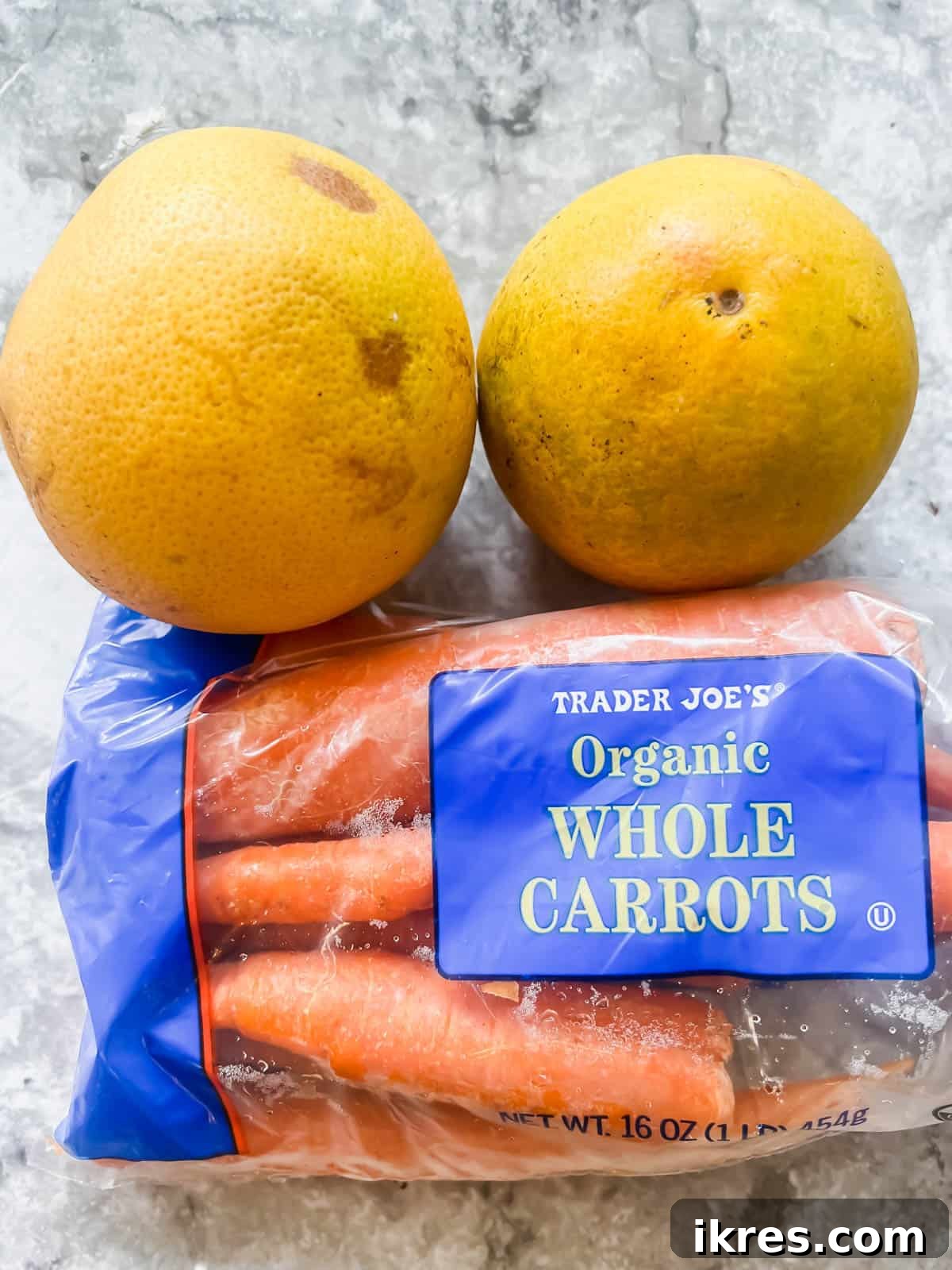 Sunshine Carrot Grapefruit Salad 4 Fresh carrots and a whole grapefruit, the two key ingredients for making Raw Carrot Salad with Grapefruit, neatly arranged for the camera.
