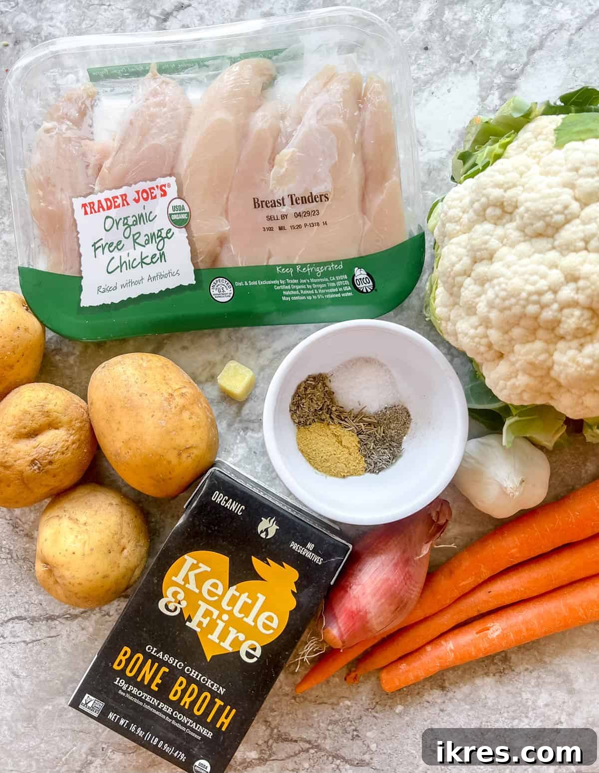 Nourishing Grain-Free Chicken Soup 3 A collection of fresh, vibrant ingredients for Paleo chicken soup, including chopped vegetables, herbs, and chicken pieces, laid out on a clean surface.