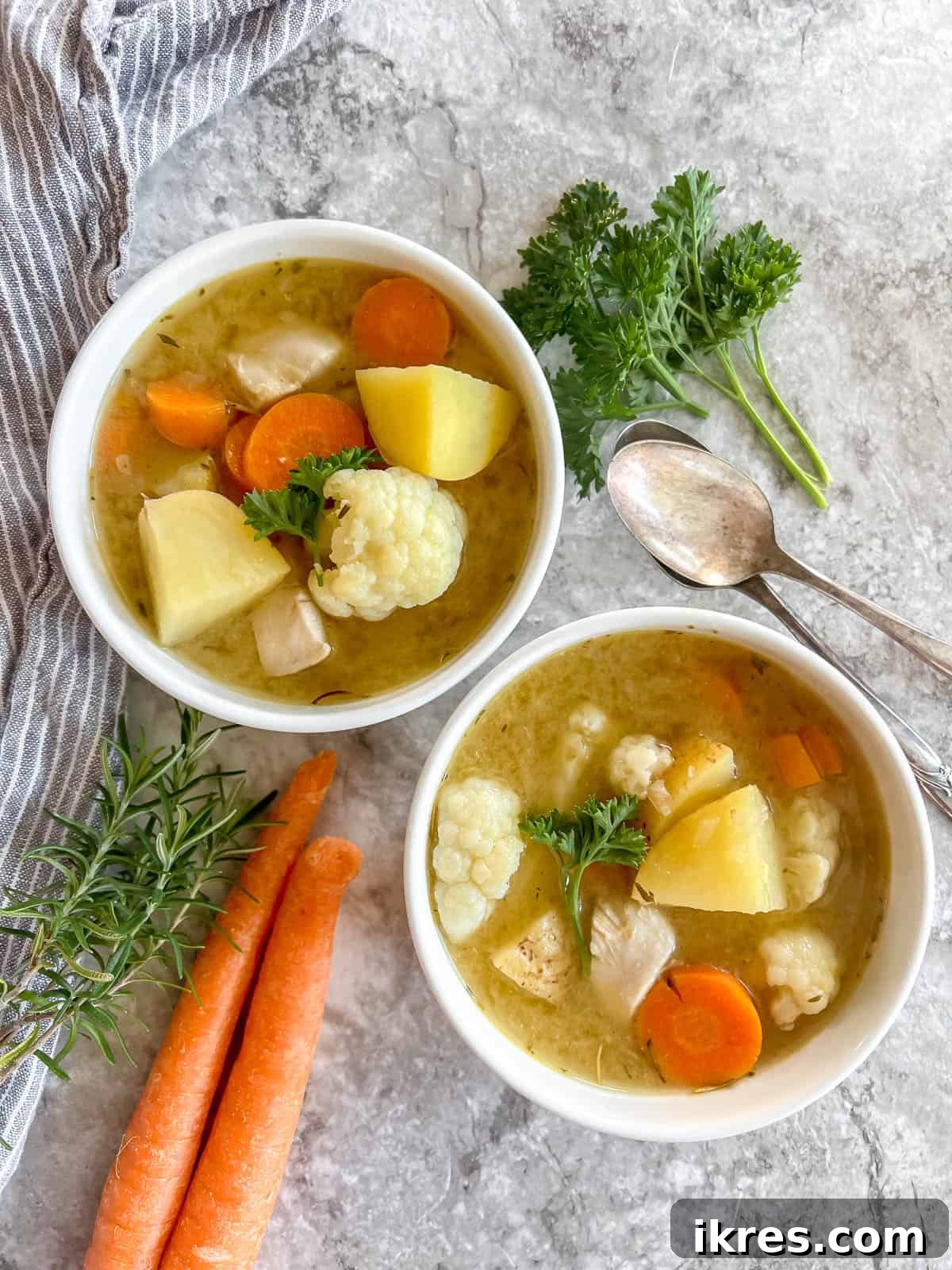 Nourishing Grain-Free Chicken Soup 8 Two bowls of inviting, healthy chicken soup, served without noodles, garnished with fresh herbs, ready to be enjoyed.