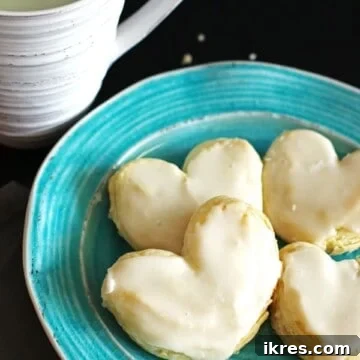 Flaky Heart Delights 2 Frosted puff pastry hearts on a turquoise plate with a glass of milk
