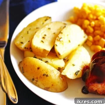 A plate with roasted potato wedges, corn, and bbq chicken.