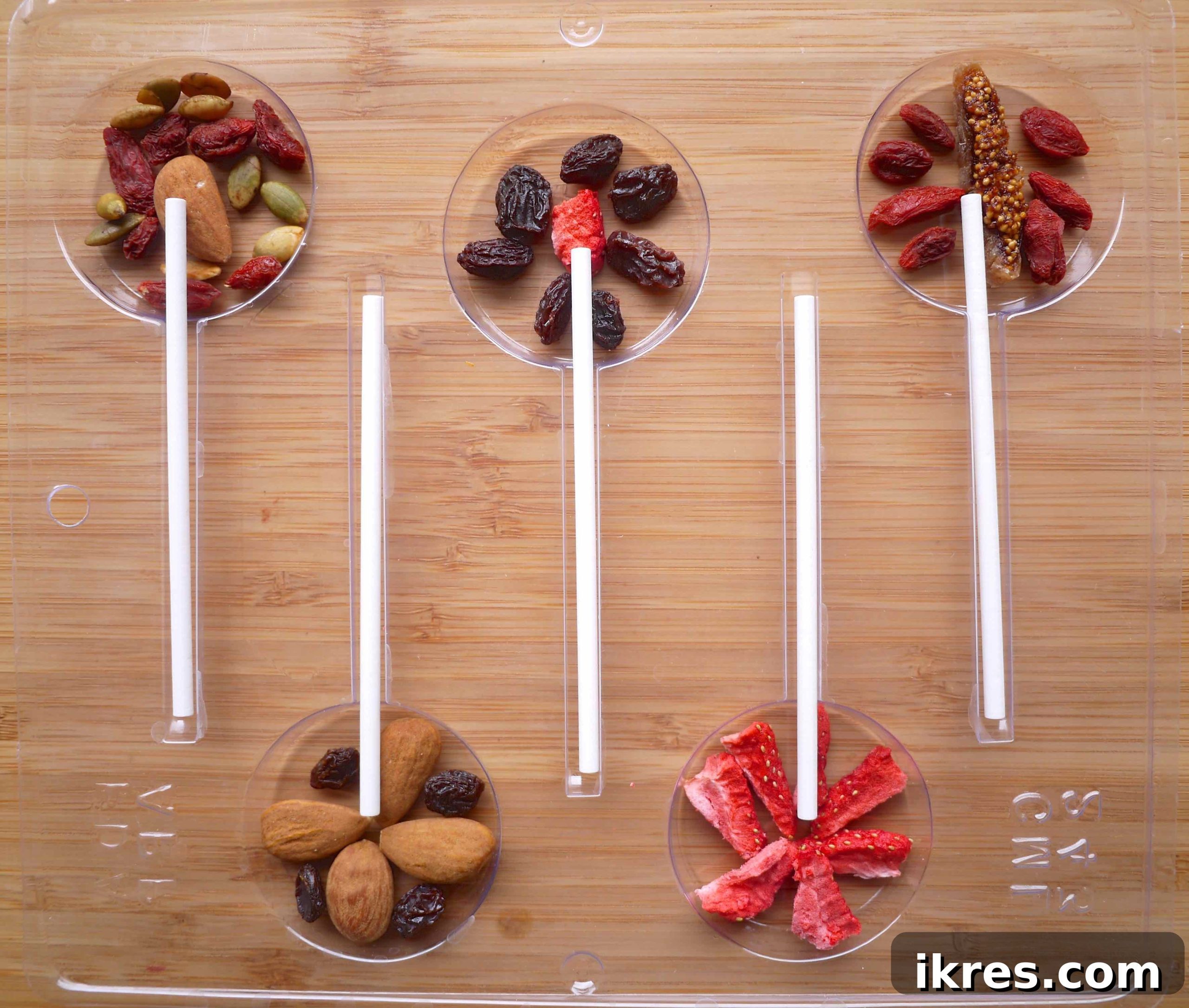 Placing lollipop sticks into the prepared molds, ensuring they are centered.