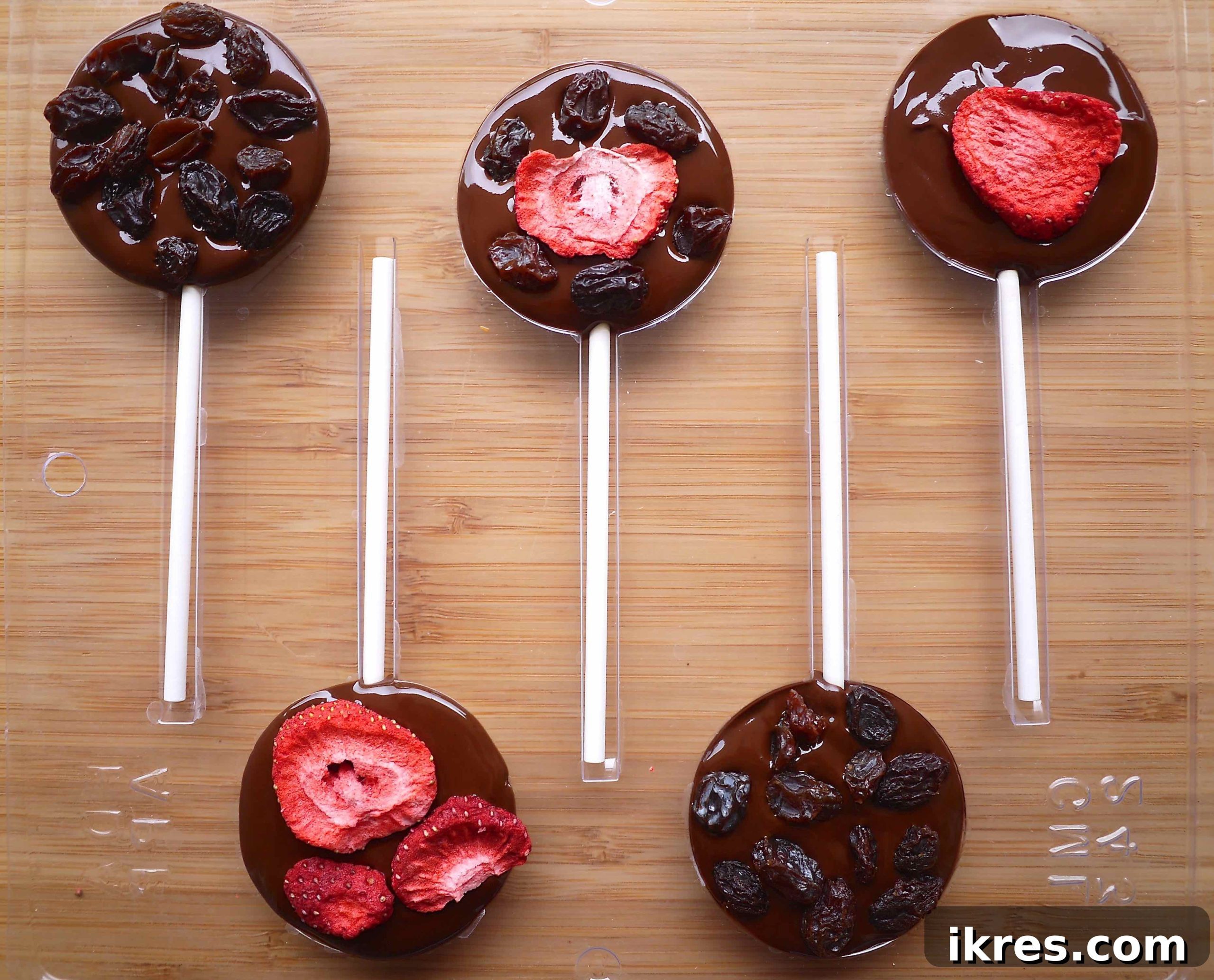 Adding additional dried fruit as a decorative topping on the freshly poured melted chocolate.