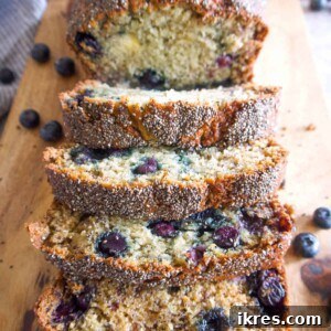 Slices of Healthy Blueberry Banana Bread with Chia Seeds on a cutting board.