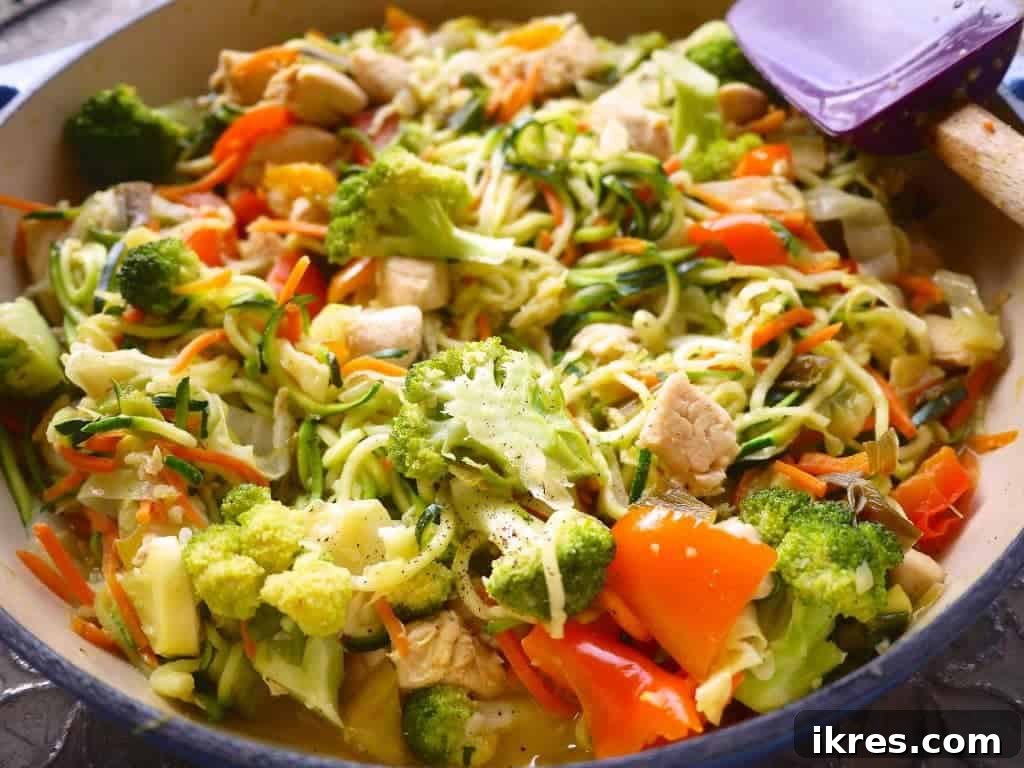 Vegetables added to the pan with chicken and sauce.