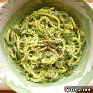 A vibrant bowl of kale and lemon pesto zoodles, a quick and healthy meal alternative.