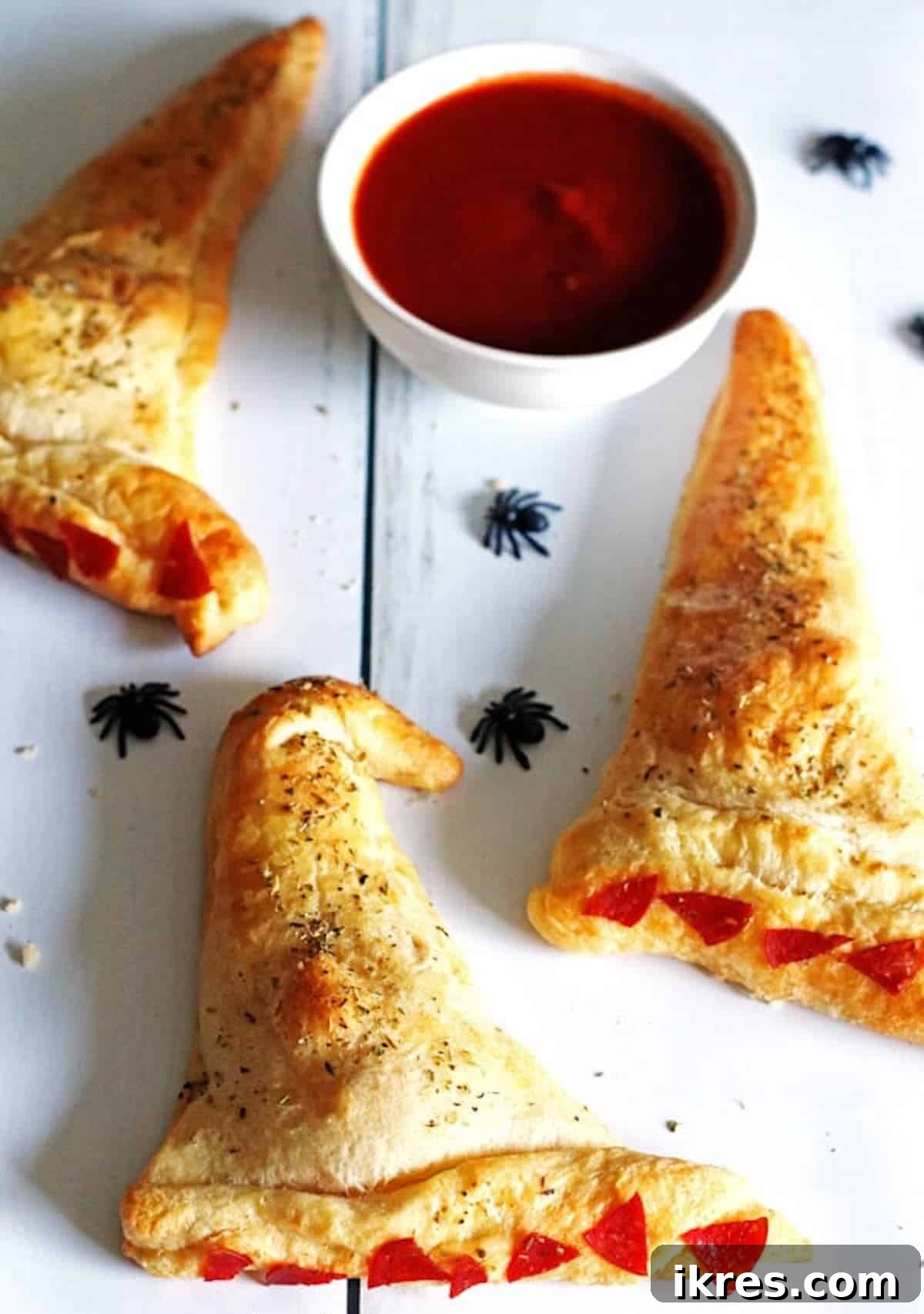 Bewitching Calzone Caps 12 Three lightly baked witch hat calzones with plastic spiders and marinara sauce.