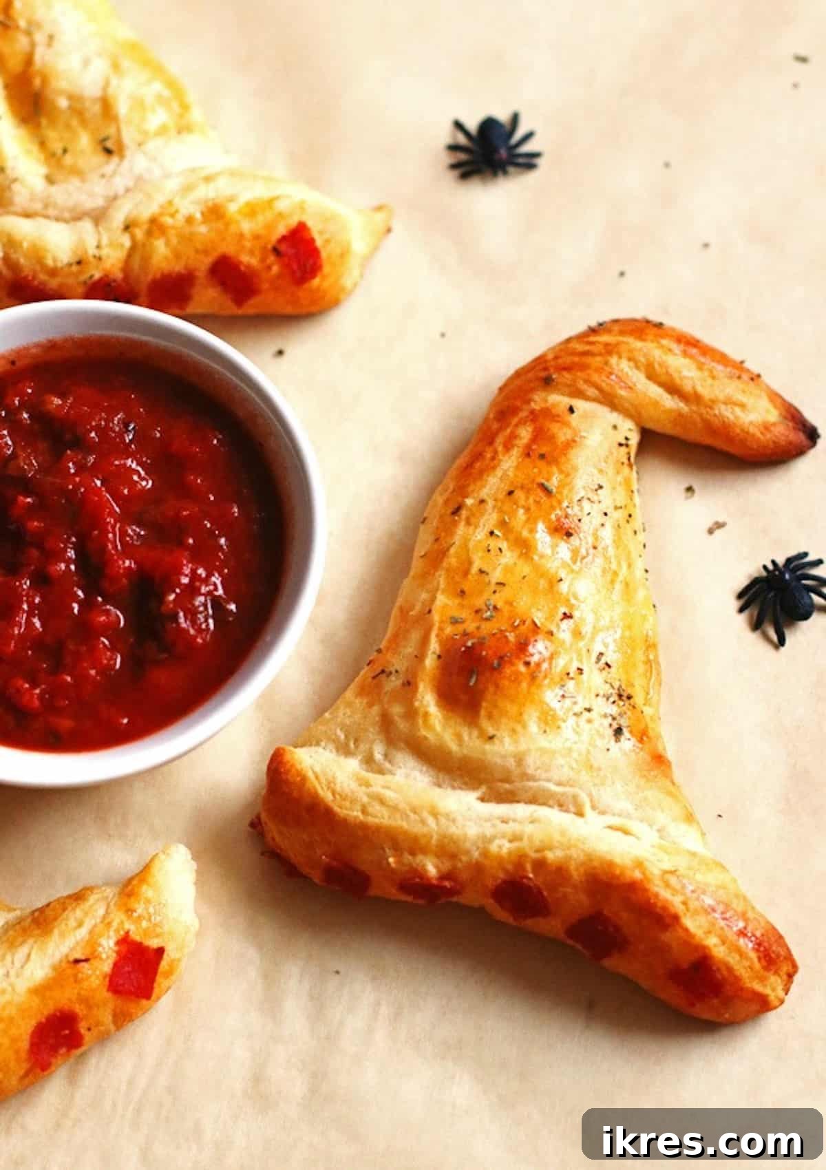 Bewitching Calzone Caps 13 A witch hat calzone and a large bowl of marinara sauce with plastic spiders.