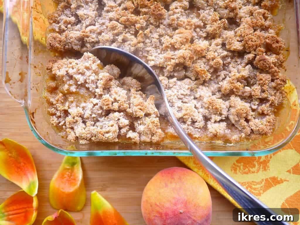 A fork raking through the prepared almond flour crumble topping to create an ideal crumbly texture.