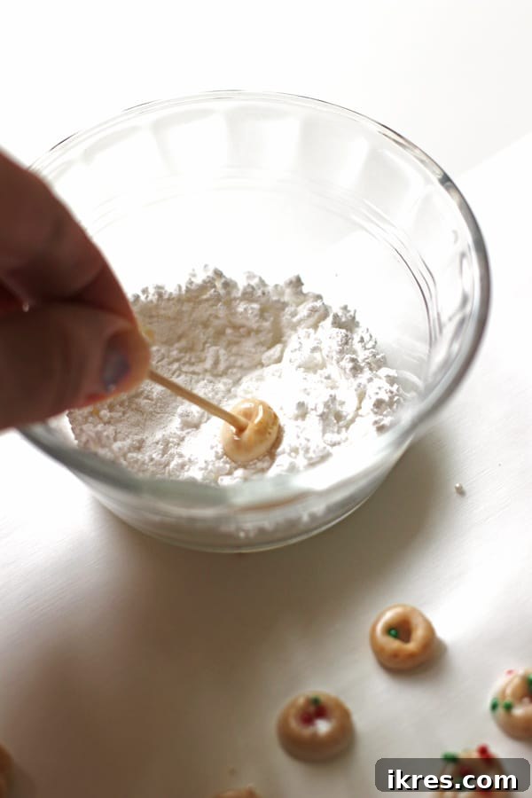 Elven Delights 5 A Cheerio, freshly dipped in glaze, is gently rolled in a small bowl of dry powdered sugar to create a classic 'powdered' Elf Donut finish.
