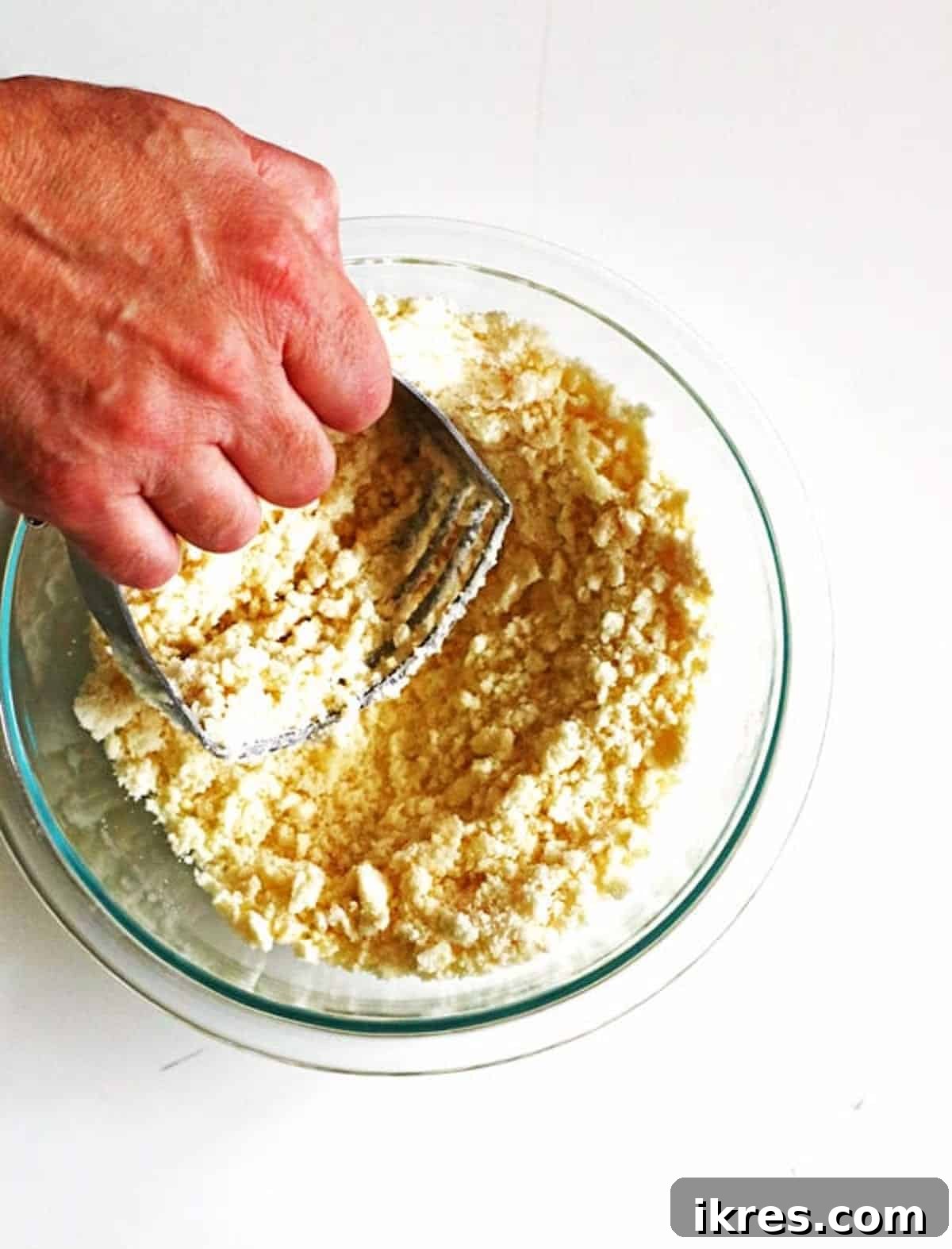 Homestyle Dutch Apple Pie 5 Making crumb topping for an apple pie by using a pastry blender to combine flour, sugar and softened butter