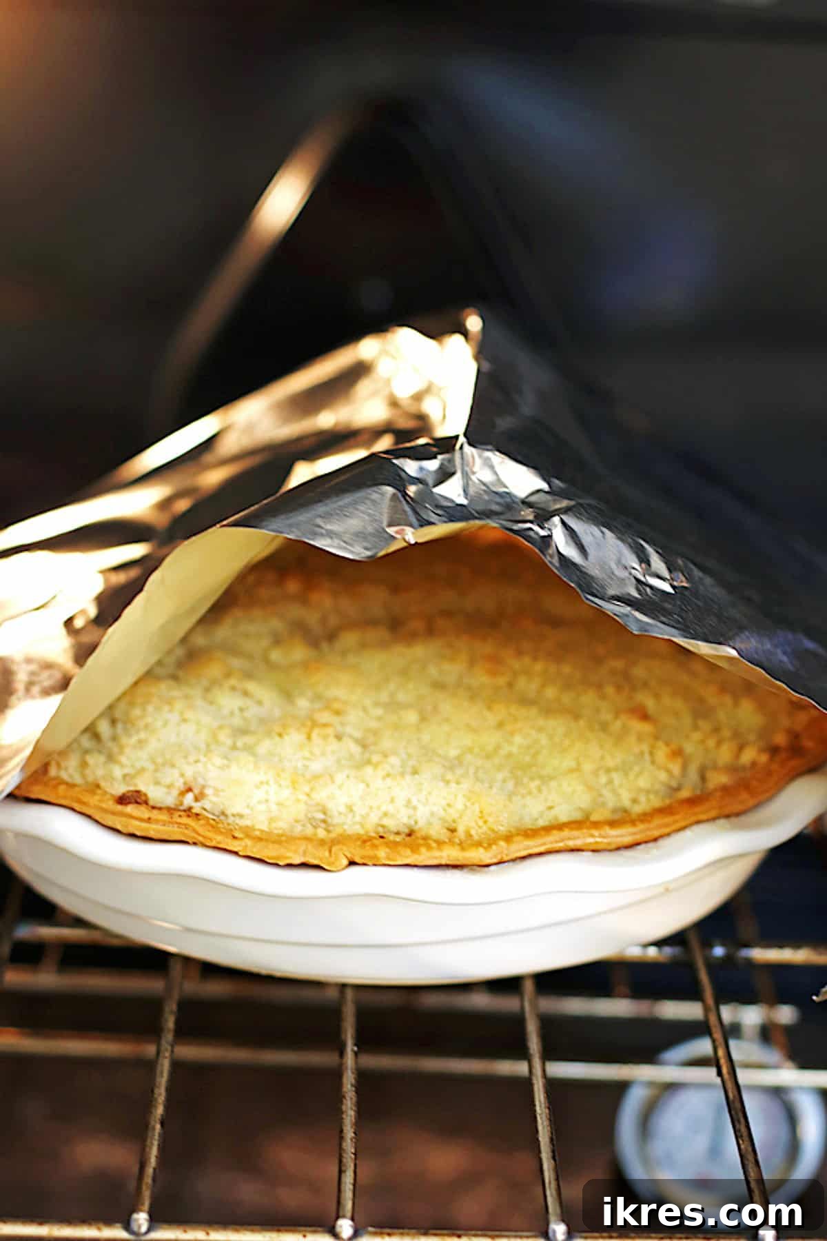 Homestyle Dutch Apple Pie 7 Apple pie in oven with foil tent over the pie