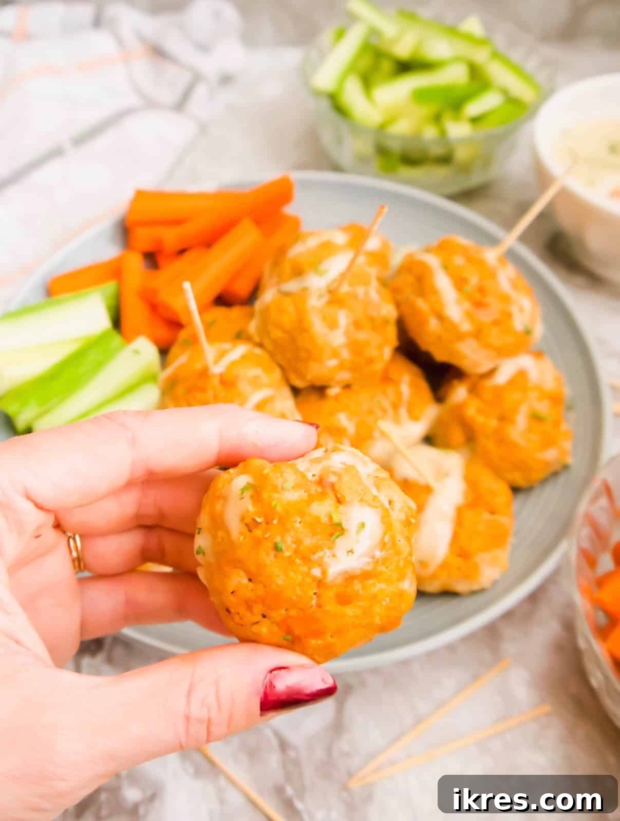 Guilt-Free Buffalo Turkey Meatballs: Your Paleo Whole30 Favorite 3 A hand holding a healthy buffalo turkey meatball, showcasing its perfect golden-brown texture.