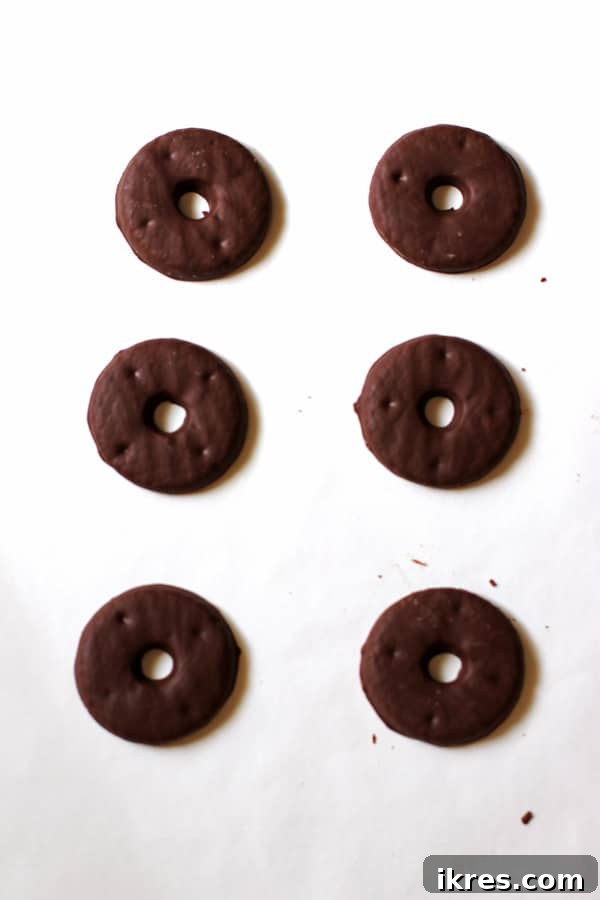 Pilgrim Hat Thanksgiving Treats 4 A single layer of chocolate-covered cookies perfectly arranged on parchment paper on a baking sheet, ready for assembly.