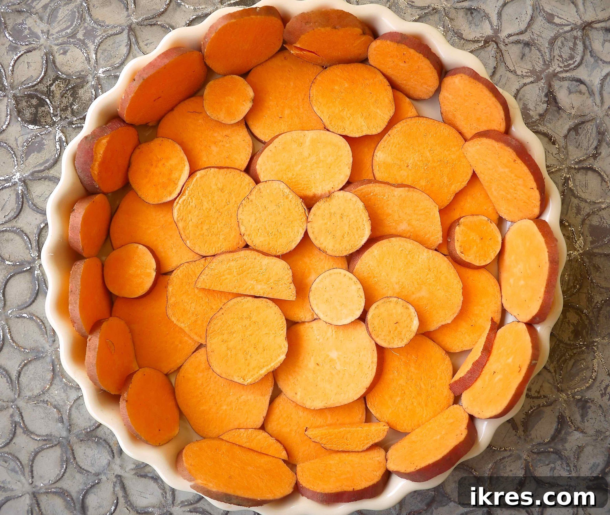 Flavorful French Tuna and Tomato Quiche on a Golden Potato Crust 3 Thinly sliced sweet potato arranged in a circular pattern in a pie dish, ready to be baked into a crust.