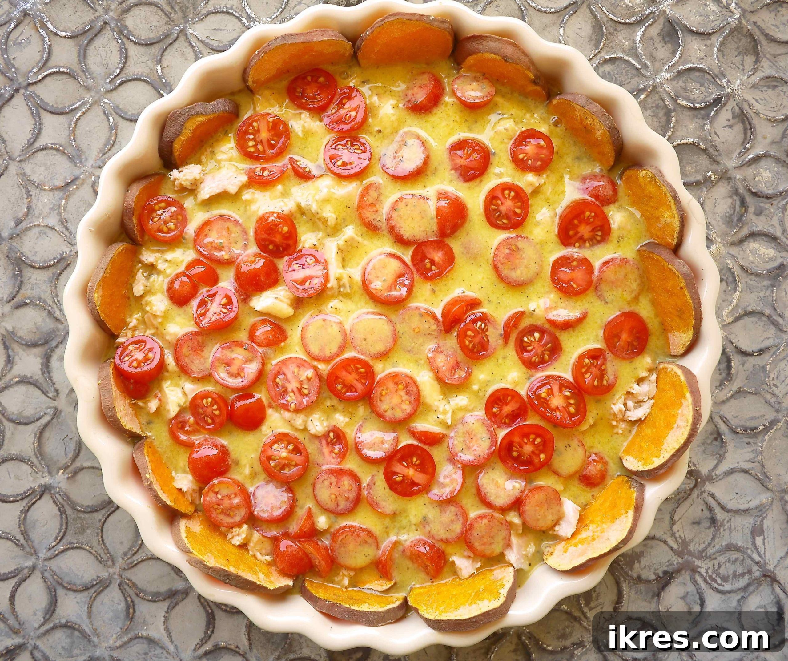 Flavorful French Tuna and Tomato Quiche on a Golden Potato Crust 6 Egg mixture with cherry tomatoes being poured into the sweet potato crust over the tuna and mustard layers.