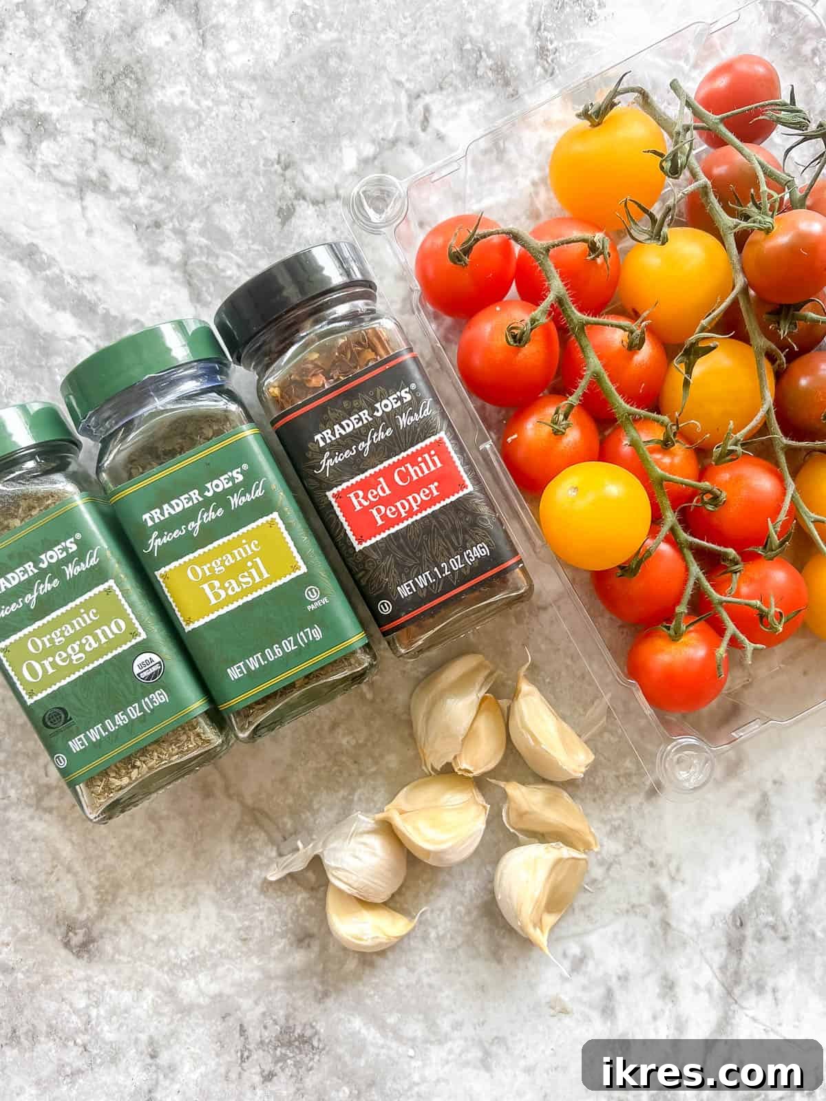 Bursting Cherry Tomato Garlic Sauce 3 A selection of fresh ingredients including olive oil, garlic, red pepper flakes, cherry tomatoes, and dried herbs, neatly arranged for making a quick cherry tomato pasta sauce.