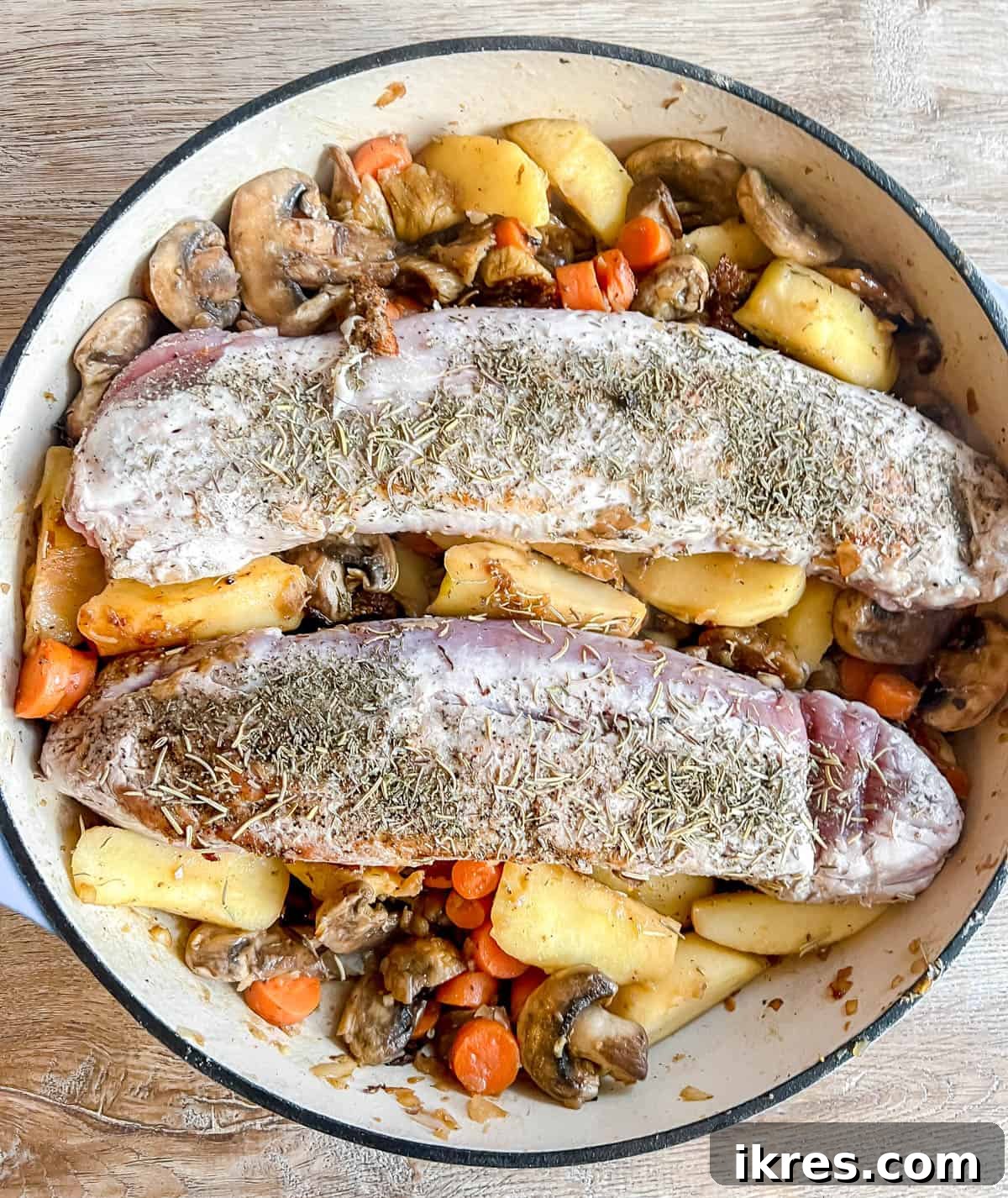 Sweet and Savory Dutch Oven Pork Tenderloin with Apples and Figs 7 Seared pork tenderloin nestled back into Dutch oven with fruits and vegetables, topped with herbs.
