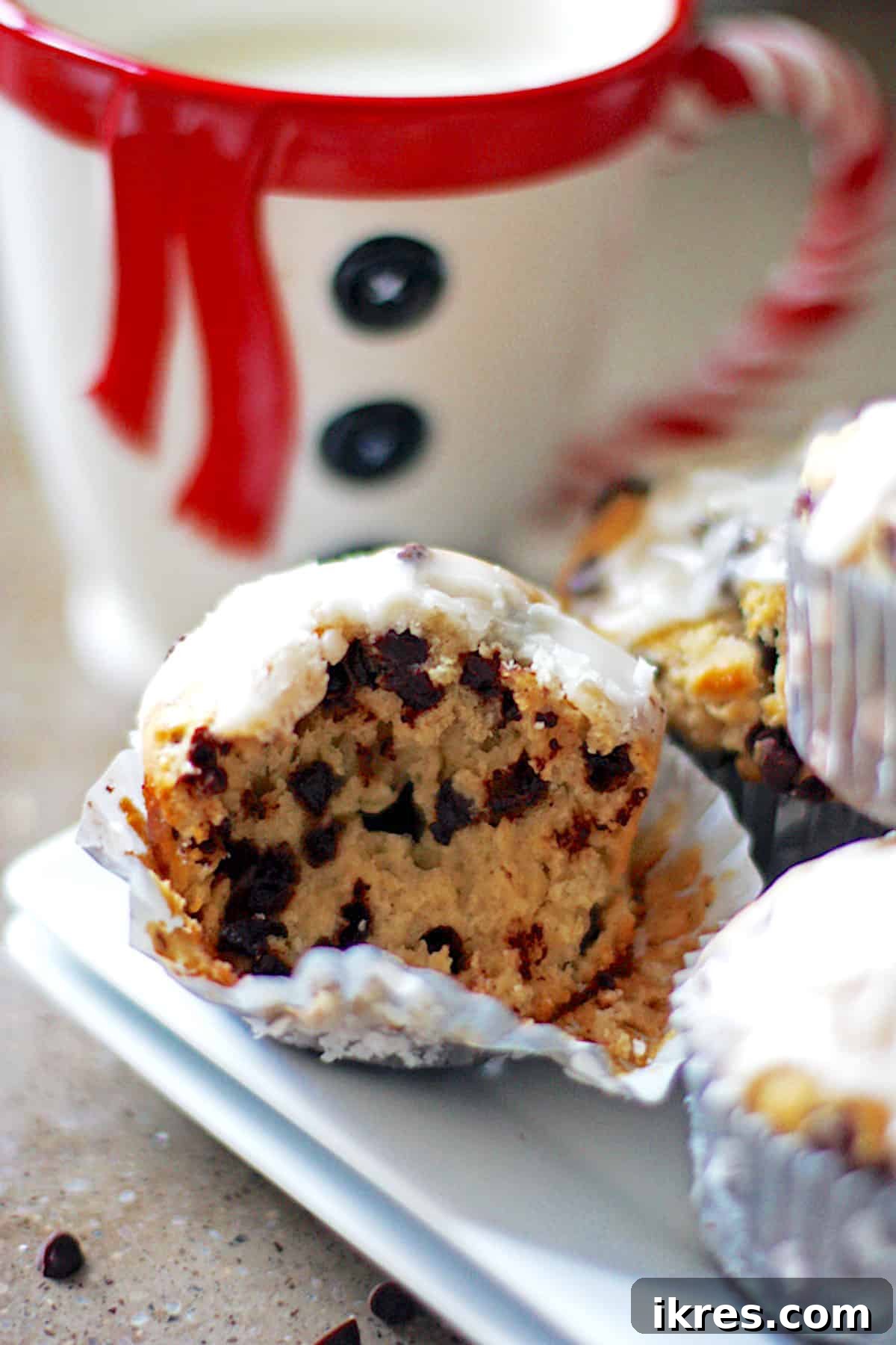 A warm banana nut chocolate chip muffin next to a mug of coffee, ready for breakfast.