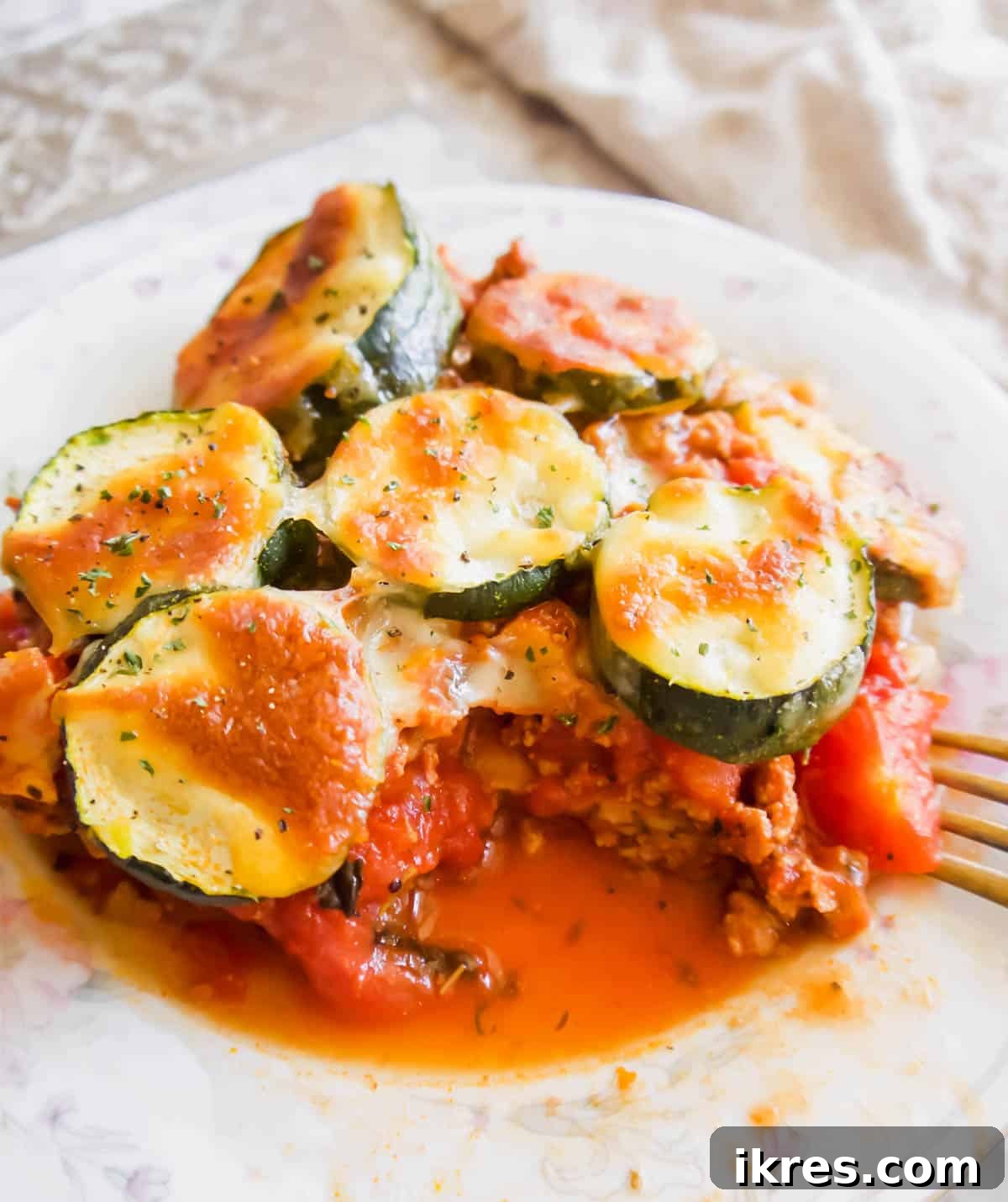 Hearty Turkey and Summer Vegetable Bake 2 A perfectly sliced portion of Zucchini, Eggplant and Ground Turkey Casserole presented on a white plate, showcasing its vibrant layers.