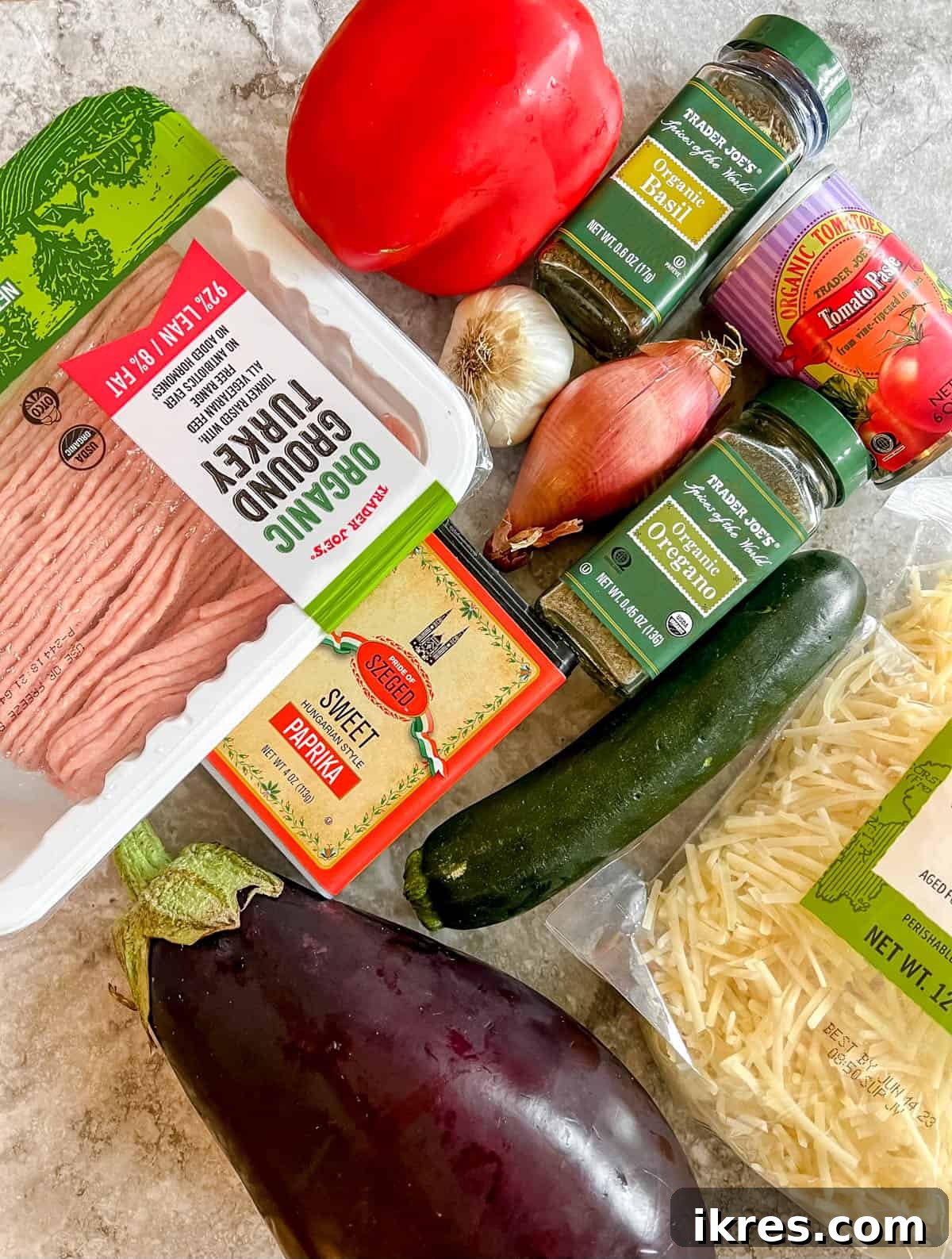 Hearty Turkey and Summer Vegetable Bake 3 A vibrant selection of fresh ingredients laid out on a kitchen counter, including eggplant, zucchini, bell peppers, onions, garlic, ground turkey, and various seasonings, ready for the eggplant ground turkey recipe.
